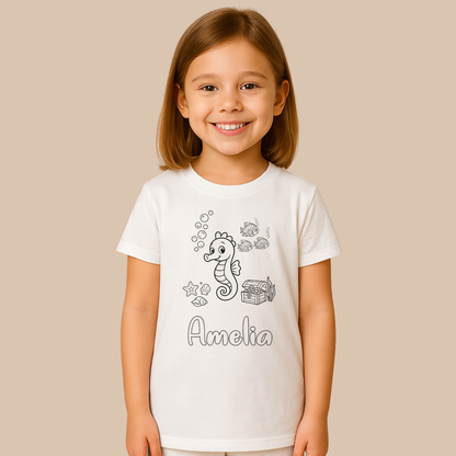 Child wearing a white t-shirt with a seahorse design and the name 'Amelia' on a beige background