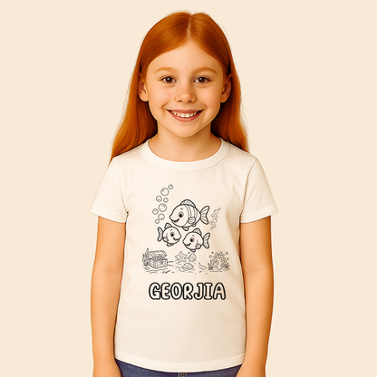 Young girl wearing a white t-shirt with cartoon fish design and 'GEORGIA' text on a beige background