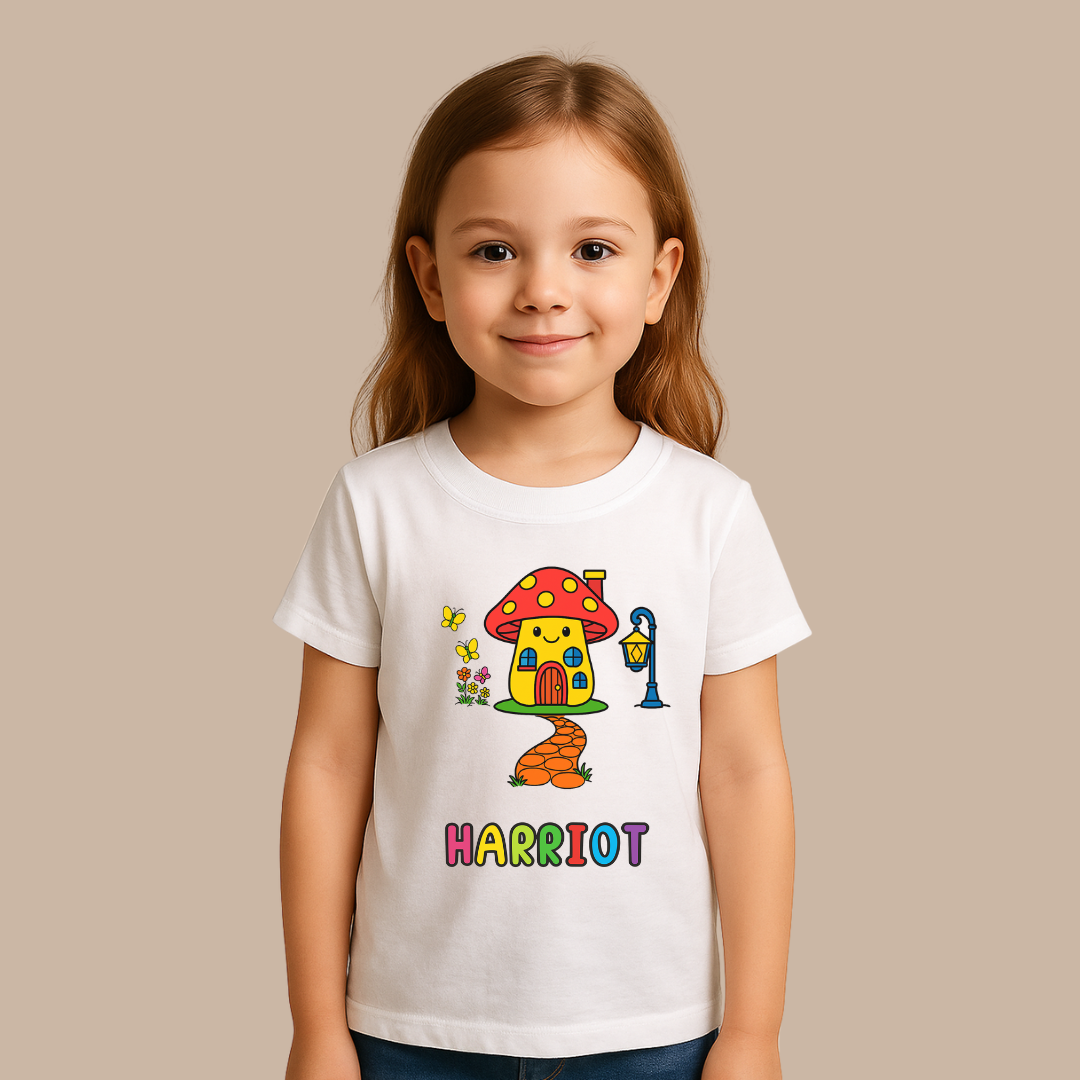 Child wearing a white t-shirt with a colorful mushroom house design and the name 'Harriot'.