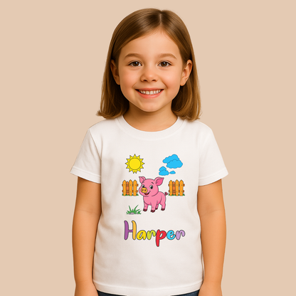 Young girl wearing a white t-shirt with a cartoon pig design and the name 'Harper' on a beige background