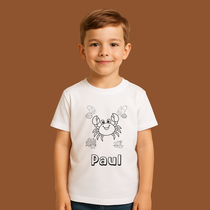 Child wearing a white t-shirt with a crab design and the name 'Paul' on a brown background