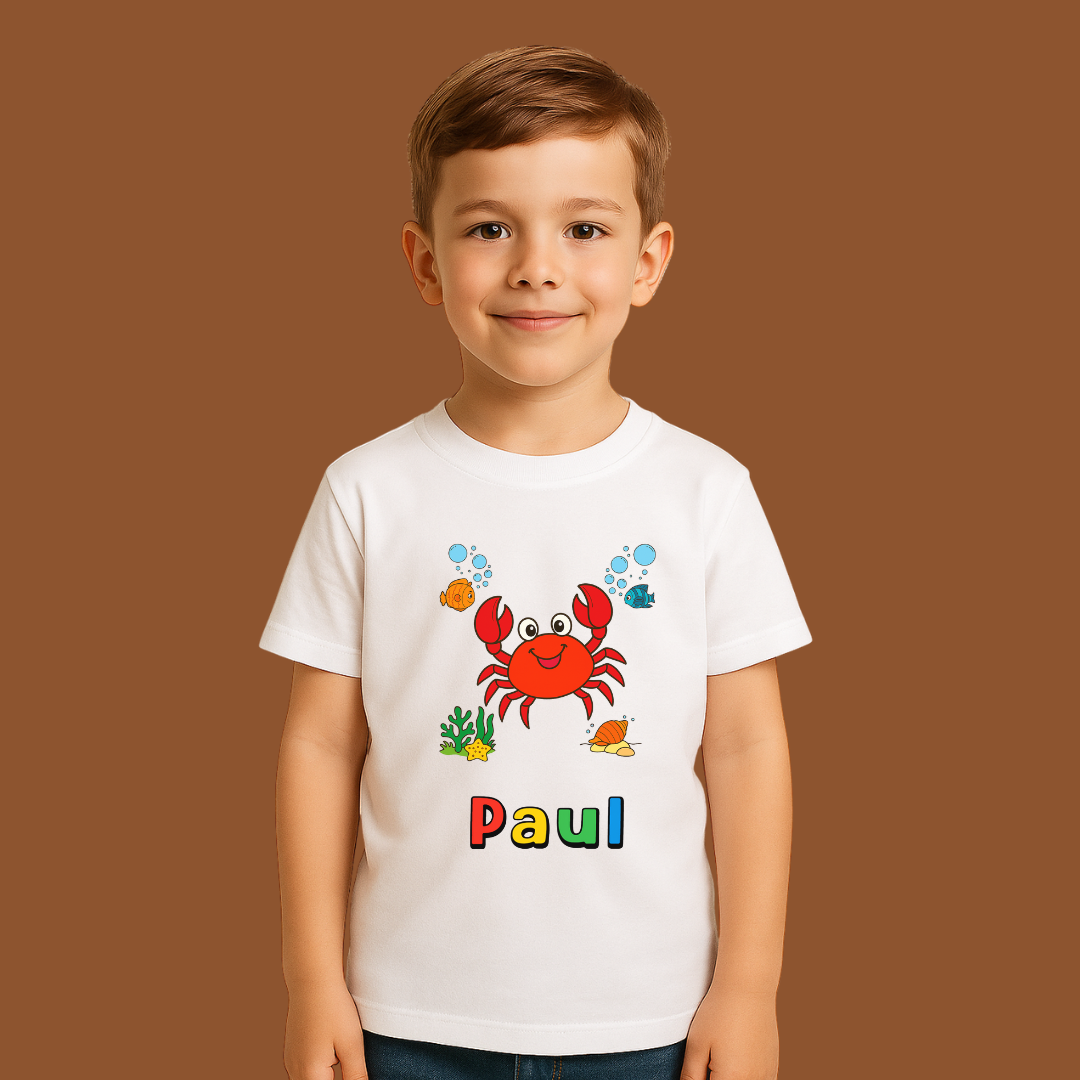 Child wearing a white t-shirt with a colorful crab design and the name 'Paul' on a brown background