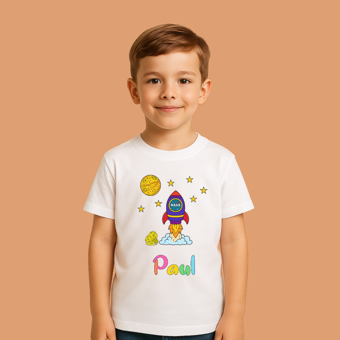 Child wearing a white t-shirt with space-themed design and name 'Paul' on a beige background