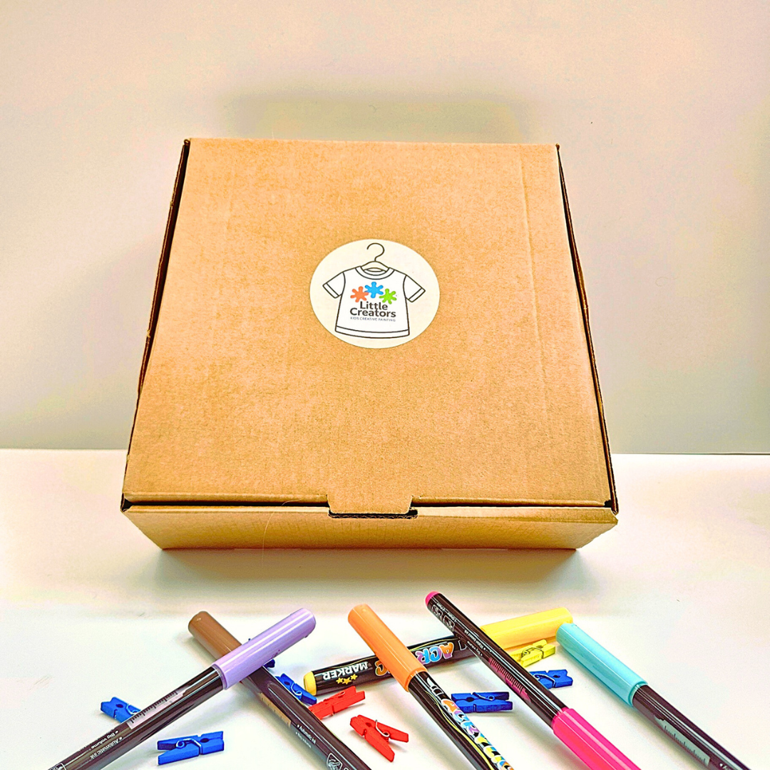 Cardboard box with a sticker and markers on a light surface