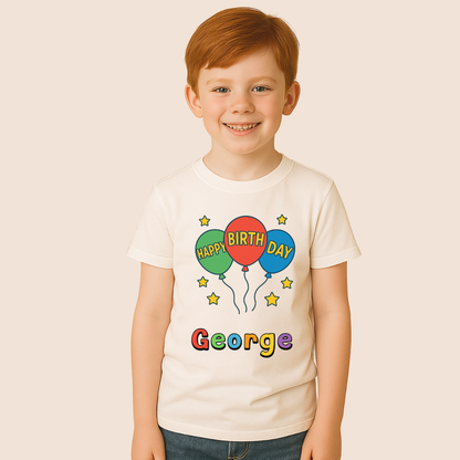 Child wearing a white t-shirt with colorful 'Happy Birthday' design and name 'George'.