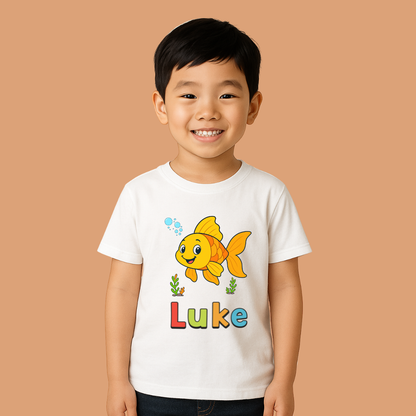 Child wearing a white t-shirt with a goldfish graphic and 'Luke' text on a beige background