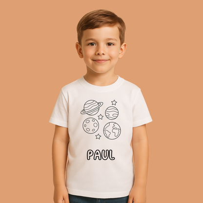 Child wearing a white t-shirt with space-themed graphics and the name 'PAUL' on a beige background