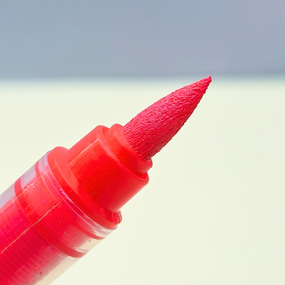 Red marker with a textured cap on a light background